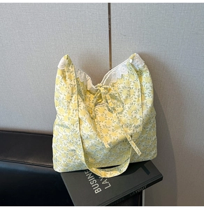 Gros plan du sac fourre-tout à fleurs avec bordure en dentelle blanche et petit nœud