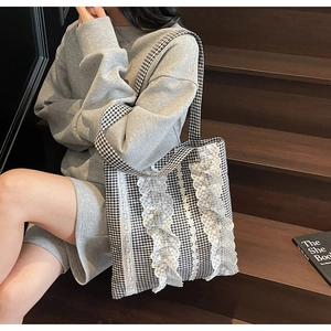 Detailed shot of black and white plaid canvas tote bag with elegant white lace trimmings
