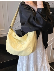 Sac hobo tendance jaune pâle avec broderie étoile porté par un mannequin