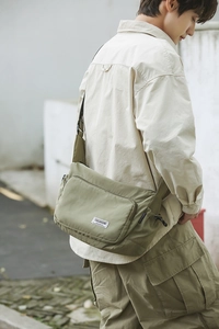 Detail view of water-resistant nylon dumpling bag with adjustable side drawstrings
