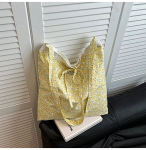 Détail du sac cabas en toile à fleurs jaunes avec dentelle blanche et cordon de serrage