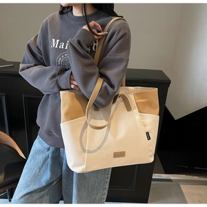 Detail van beige en kaki canvas tote bag met lederen logo en handige zijzakken