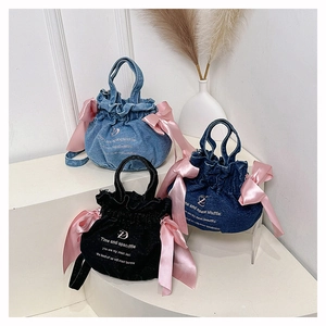 Trois sacs seaux en denim avec grands nœuds en satin rose en bleu clair, bleu foncé et noir