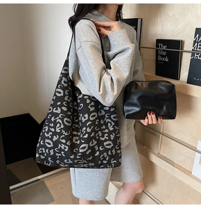 Detalle de bolso de lona con estampado de leopardo gris y neceser negro a juego
