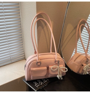 Bright pink glossy underarm bag featuring pearl bow charm and double front pockets