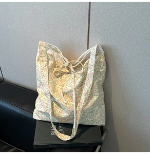 Détail d'un sac cabas floral avec des bords en dentelle élégants et un petit nœud en ruban