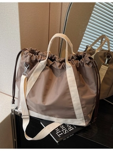 Minimalist large brown drawstring tote bag with off-white straps for casual styling