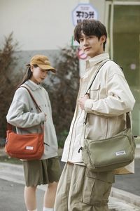 Street style shot of waterproof nylon crossbody bags in orange and olive green colors