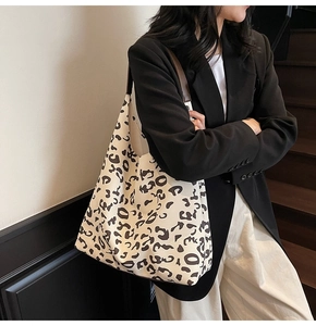 Detalle de bolso tote grande con estampado de leopardo y correas de cuero marrón vintage