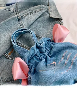 Détails du sac seau en denim avec nœuds en satin rose et broderie personnalisée