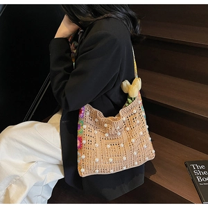 Detail der gewebten Tasche mit weißen Perlen, Häkelblumen und gelben Tulpen