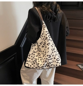Detalle de bolsa tote grande con estampado de vaca y correas de cuero sintético marrón