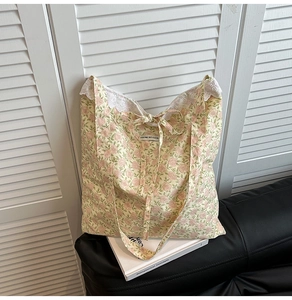 Détail macro du sac cabas floral avec bordure en dentelle blanche et nœud décoratif