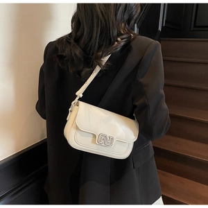 Detail of a creamy white PU leather square bag with a silver geometric buckle