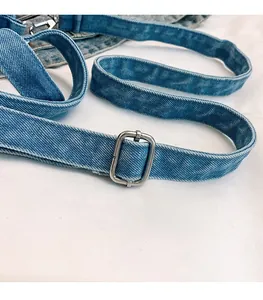 Détail d'une bandoulière en denim bleu avec boucle en métal argenté réglable