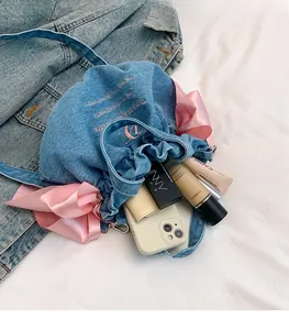 Gros plan du sac seau en denim montrant de grands nœuds roses et l'espace intérieur