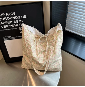 Détail du sac cabas floral vert clair avec dentelle blanche et fermeture par nœud