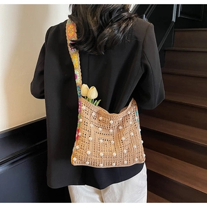 Detail der gehäkelten Handtasche mit Perlen und buntem floralen Schultergurt