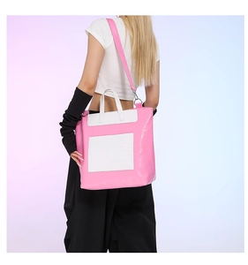 Detail of pink and white faux leather tote bag with adjustable shoulder strap
