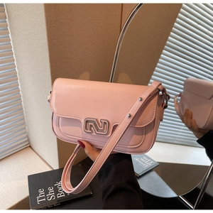 Detailed view of pink crossbody bag with silver metal lock and adjustable shoulder strap