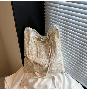 Détail du sac cabas en toile fleurie avec bordure en dentelle et nœud décoratif