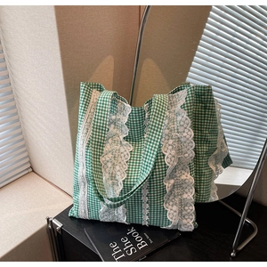 Detailed close-up of lace-trimmed green gingham tote bag with floral lace edge details
