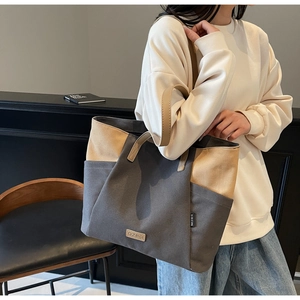 Gedragen beeld van een grote tweekleurige canvas shopper met minimalistisch ontwerp