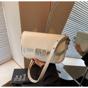 Detail of cream leather shoulder bag with chic silver metal buckle and soft shadow