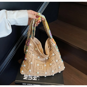 Détail d'un sac cabas tissé à la main avec perles blanches et poignée à motifs colorés