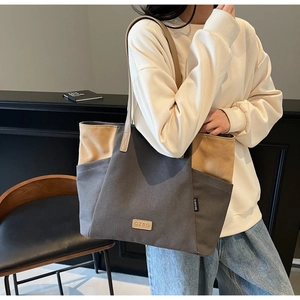 Detail van de grote canvas shopper met kleurvlakken en leren handvatten voor dagelijks gebruik
