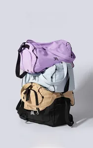 Sacs de voyage en toile empilés verticalement en violet, bleu clair, kaki et noir