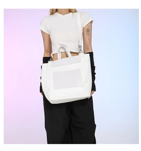 Detail of white large capacity tote bag with crocodile texture pockets and shoulder strap
