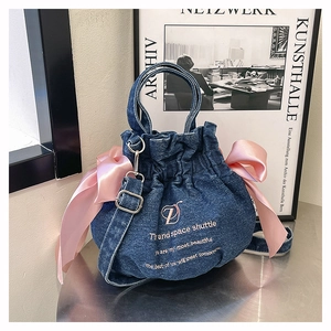 Détail du sac seau en denim avec rubans roses et logo ZD brodé sur le devant du sac
