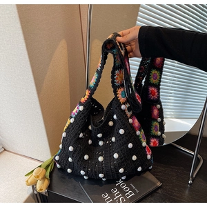 Détail d'un sac au crochet noir fait main avec motifs floraux et perles décoratives