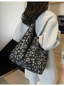 Bolso tote grande con estampado de leopardo llevado por una modelo en interior minimalista