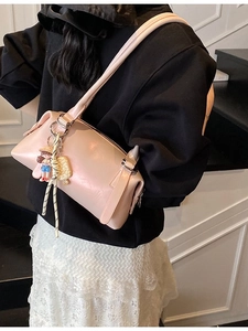 Pale pink leather shoulder bag for women with cute cartoon charm in a stylish commute look
