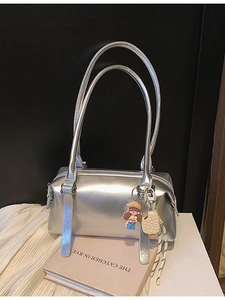 Silver metallic Boston shoulder bag with cute charms on a book and white fabric