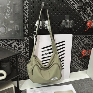 Close-up of olive green waterproof nylon crossbody bag with adjustable strap and front zip