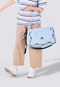 Détail du sac de voyage bleu clair avec cordon de serrage noir et bandoulière réglable