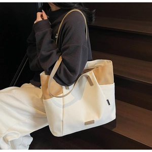 Detail van canvas tote bag met OZBG lederen patch en beige-khaki contrastkleuren
