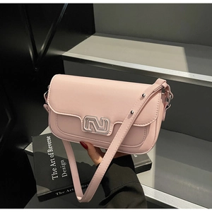Detail of light pink shoulder bag with a stylish silver geometric buckle on gray steps