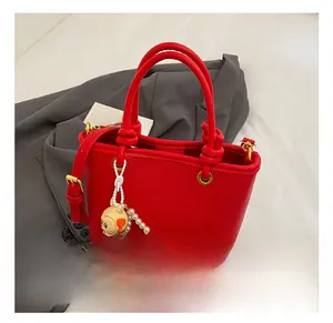 Detailed macro view of red lychee texture leather bucket bag with cute bunny pendant