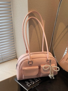 Chic pink glossy leather underarm bag with pearl bow and heart charms on book base