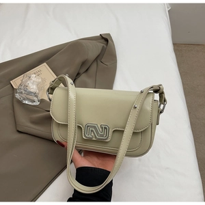 Close-up of gloss leather shoulder bag featuring silver metal buckle and flap design