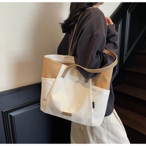 Detail van canvas tote bag met zijvak en het lederen merklabel op de tas