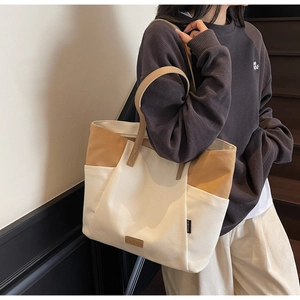 Detail van de grote canvas draagtas met zijvak en leren handvattextuur