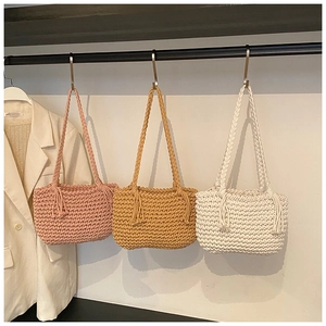 Detailed close-up of handmade woven shoulder bags with tassels and thick braided straps