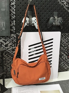 Burnt orange nylon dumpling bag with adjustable strap for sports and casual style