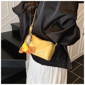 Detail of yellow barrel bag with leather elephant charm and litchi texture