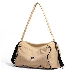 Détail du sac en nylon imperméable beige clair montrant la texture et les cordons latéraux